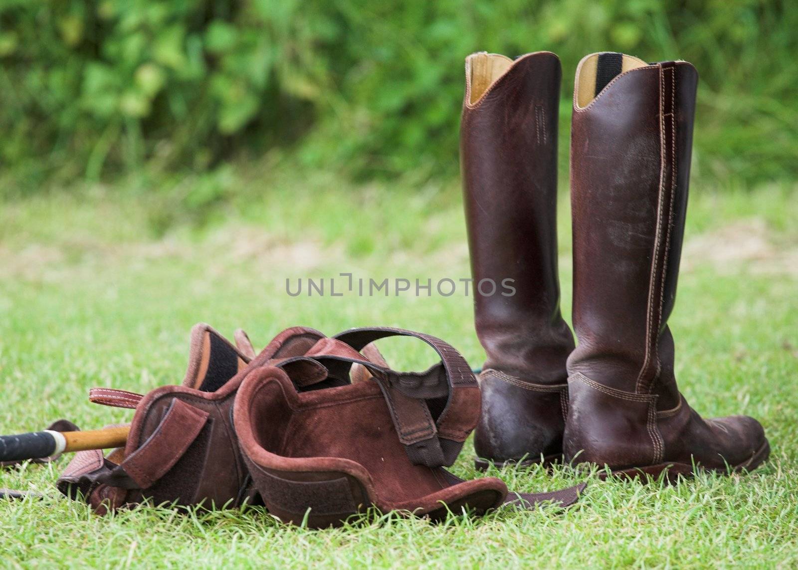 Pair of riding boots and knee protectors, ready for a game of polo.