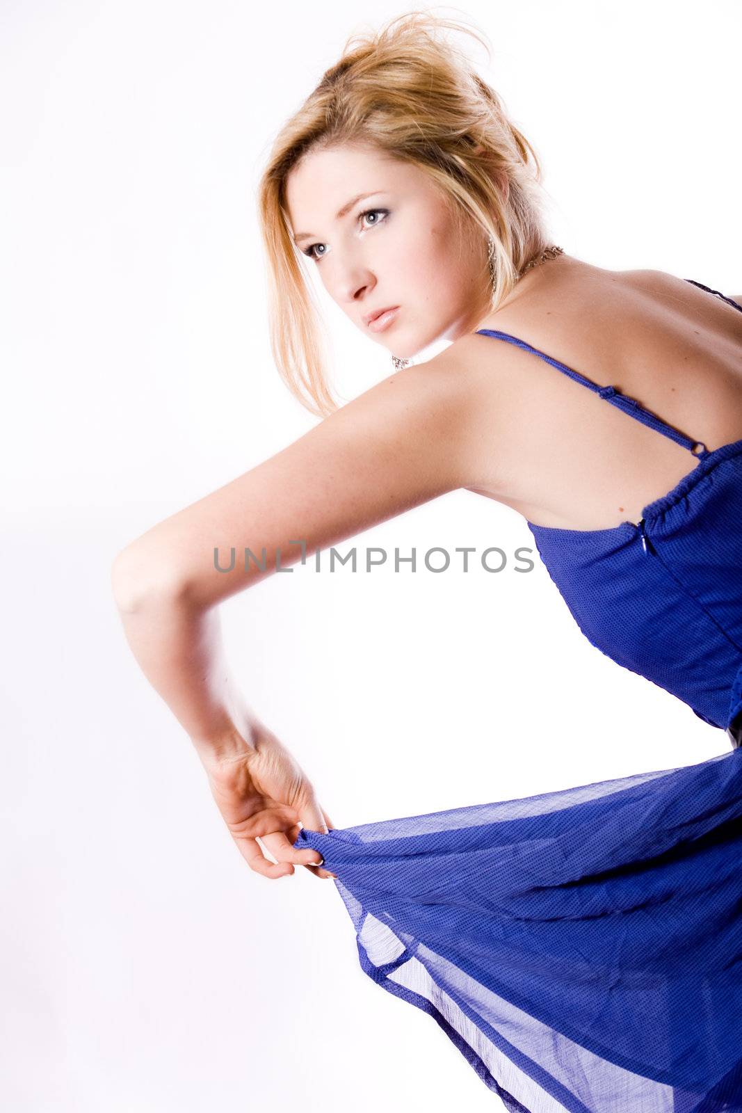 Young girl in a dress in the studio on a white background