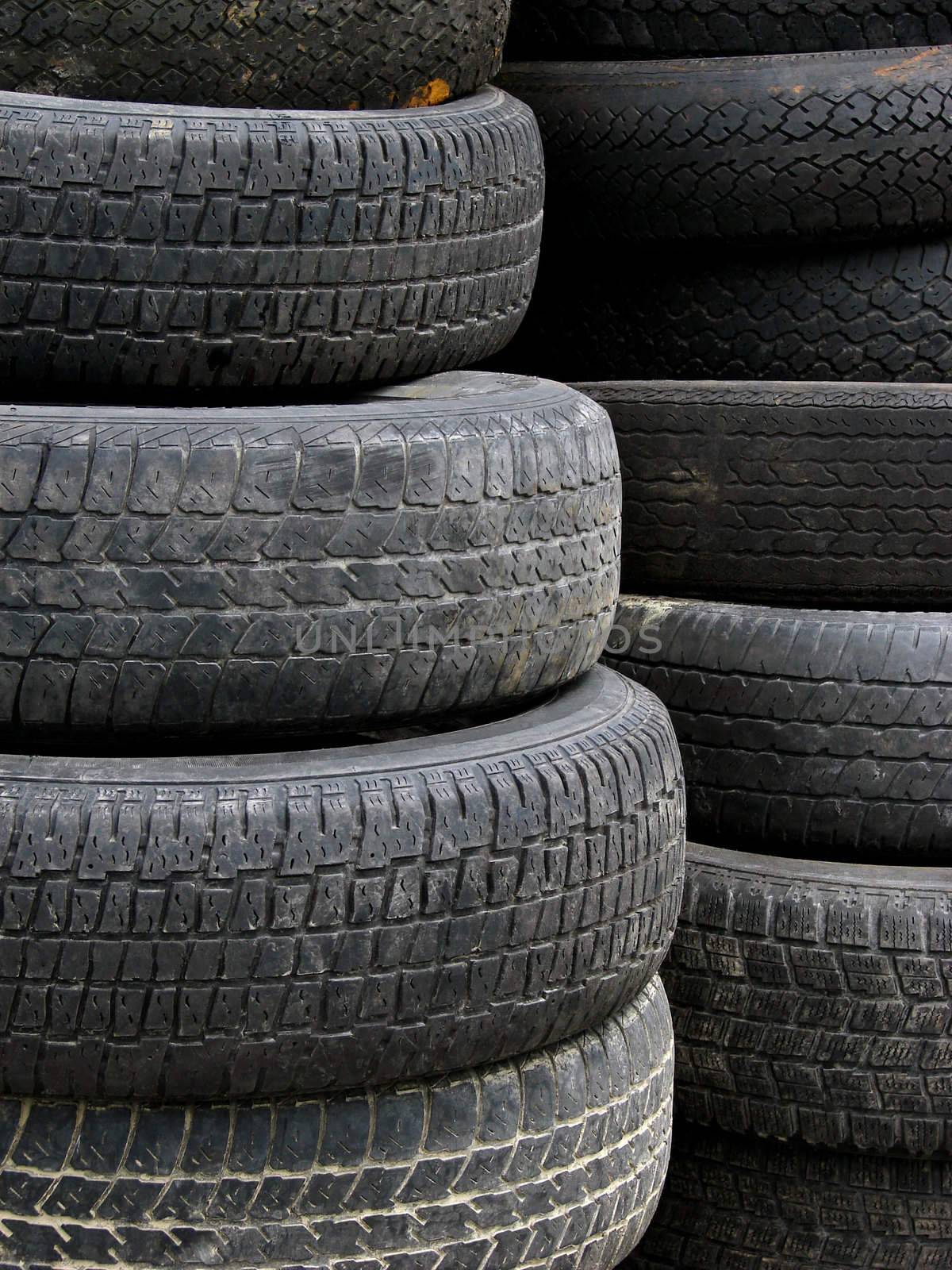 Old useless tires stacked up in two piles in a recycling plant