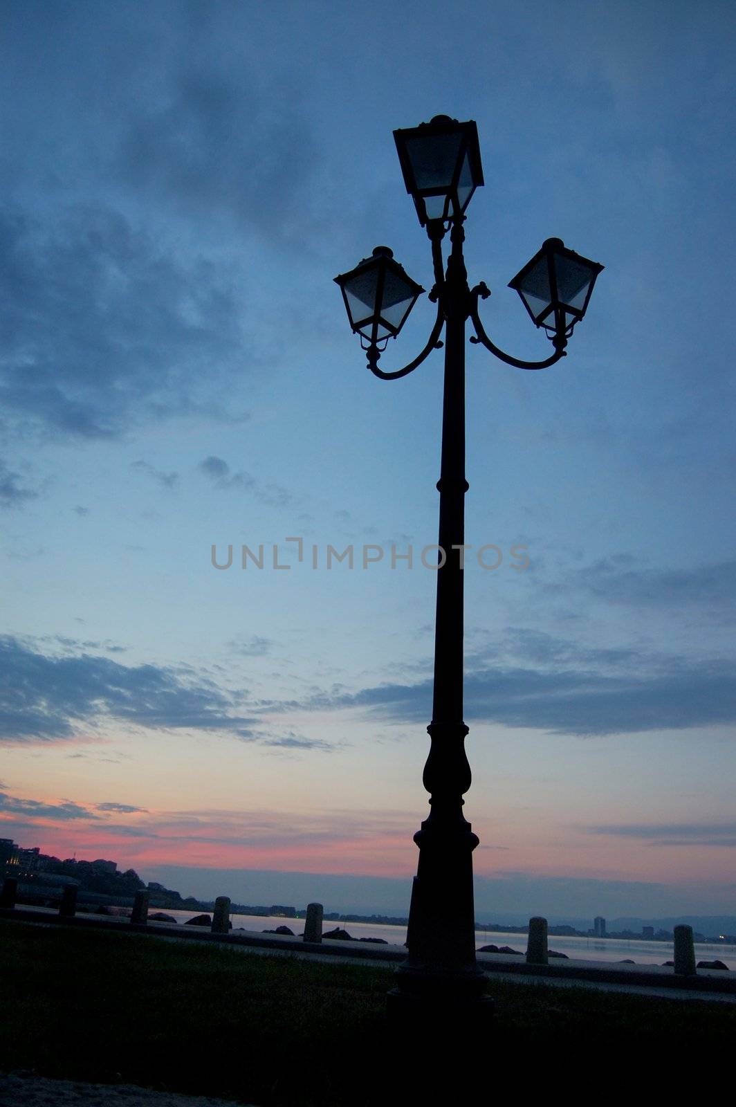 Old lantern , silhouette in the blue sky on sunset