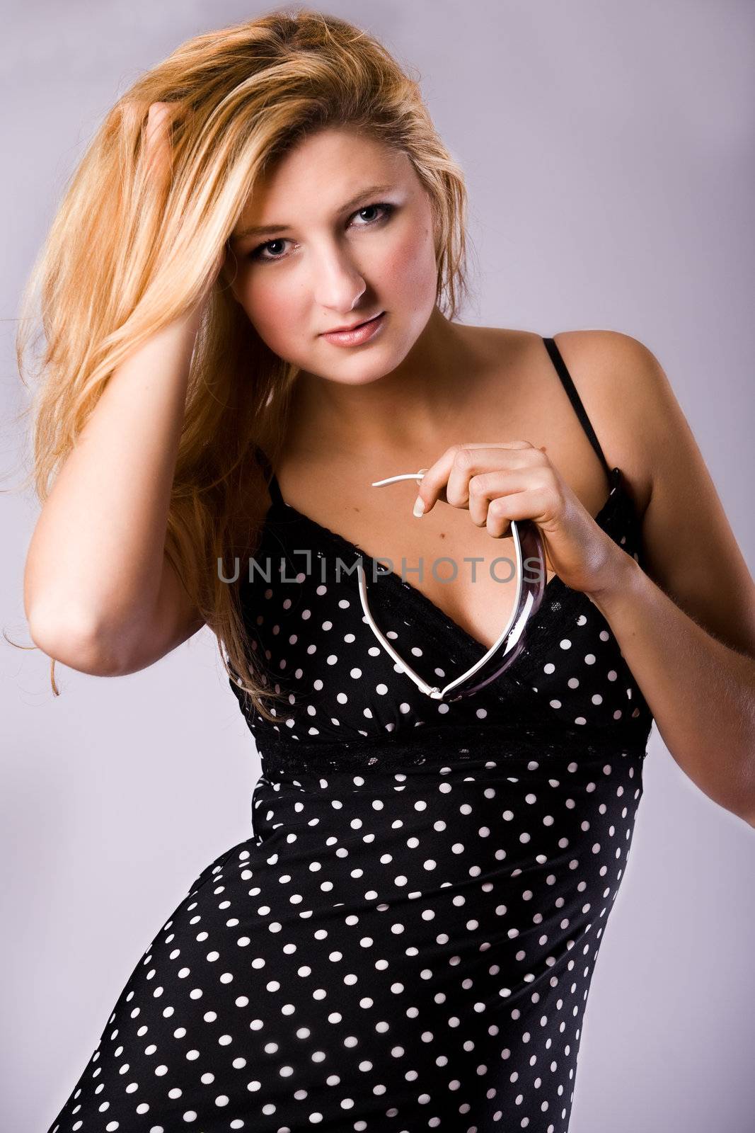 Beautiful girl with a pair off sunglasses in the studio