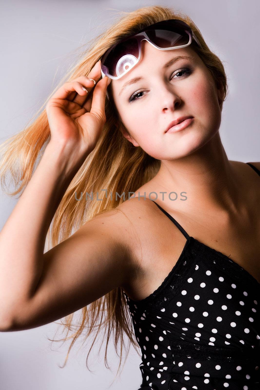 Beautiful girl with a pair off sunglasses in the studio