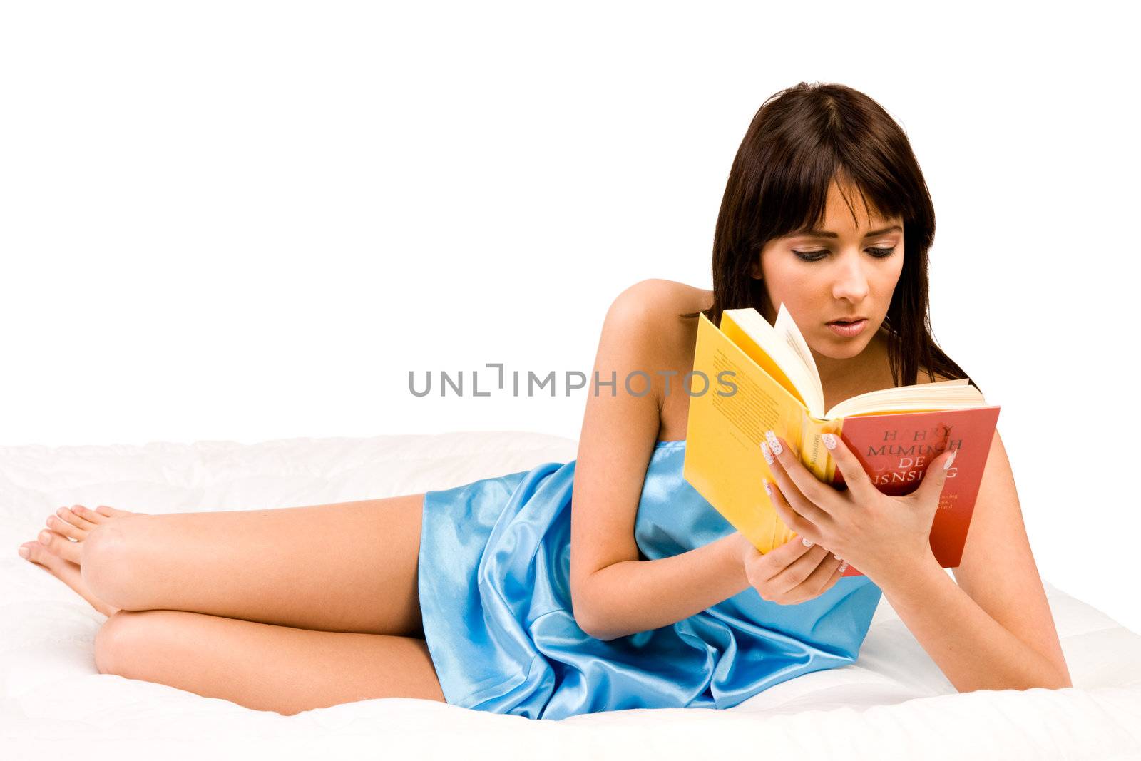 Brunette in pyjama's reading a book in bed.
Titles have been made unreadable so no copyright infrigment.