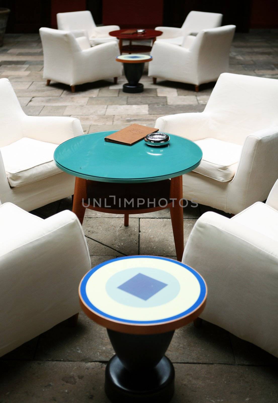 Cafe indoor with white sofas and blue glass small table