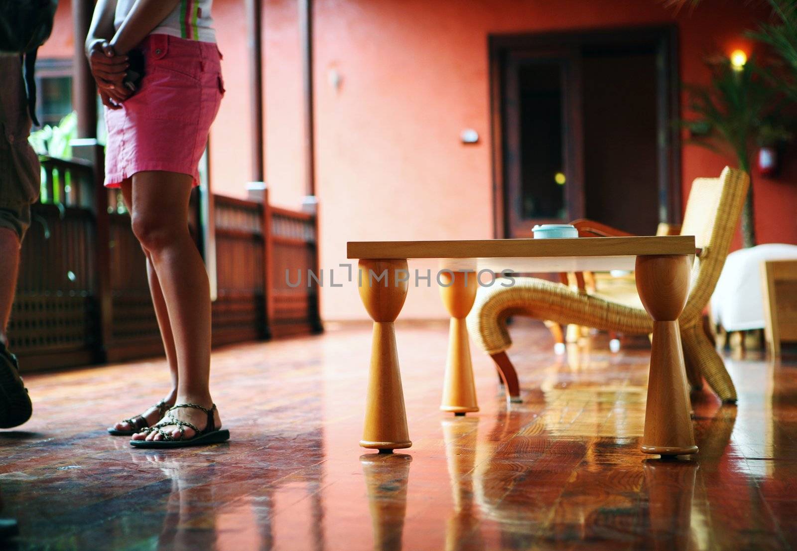 Hotel hall interior with cafe table and woman in pink skirt