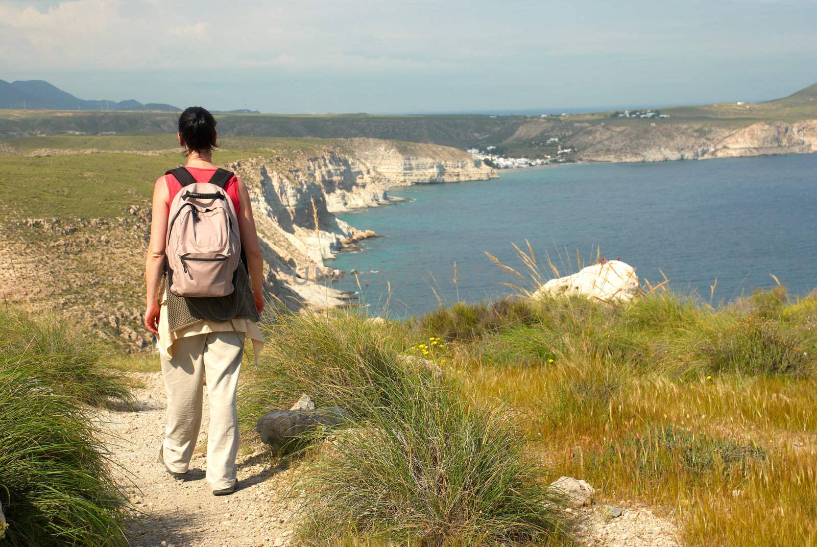 An athletic woman hiking along a cliff