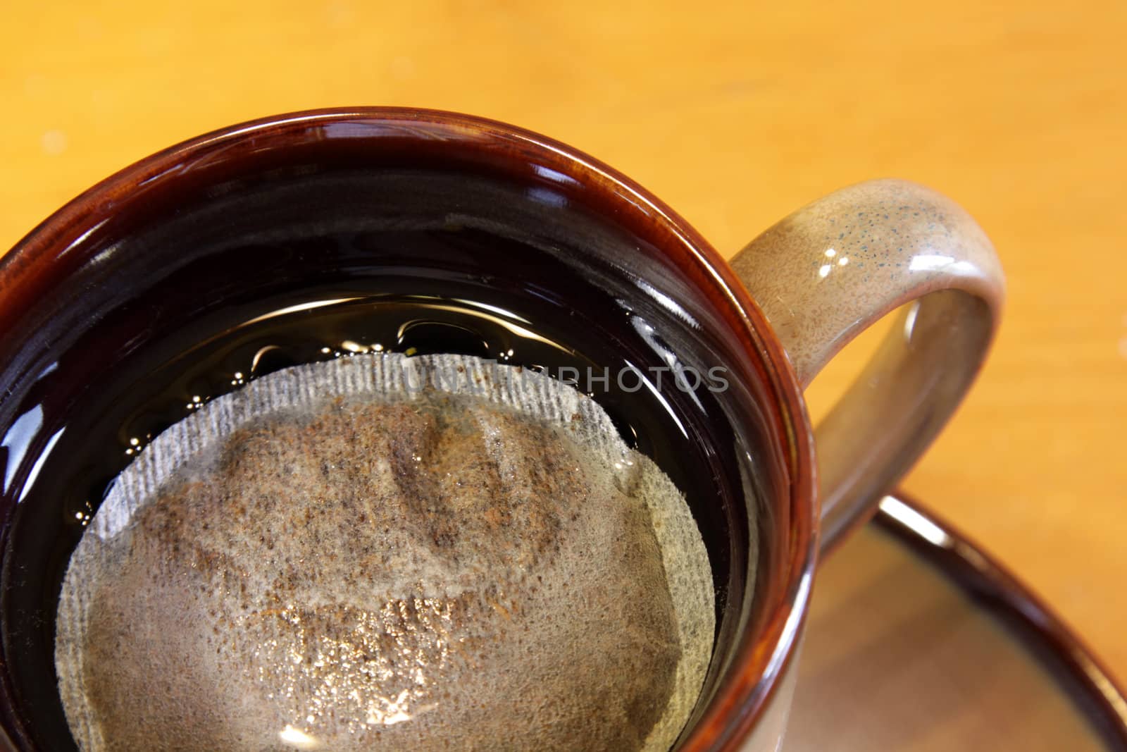 A bag of tea sitting a mug of hot water.