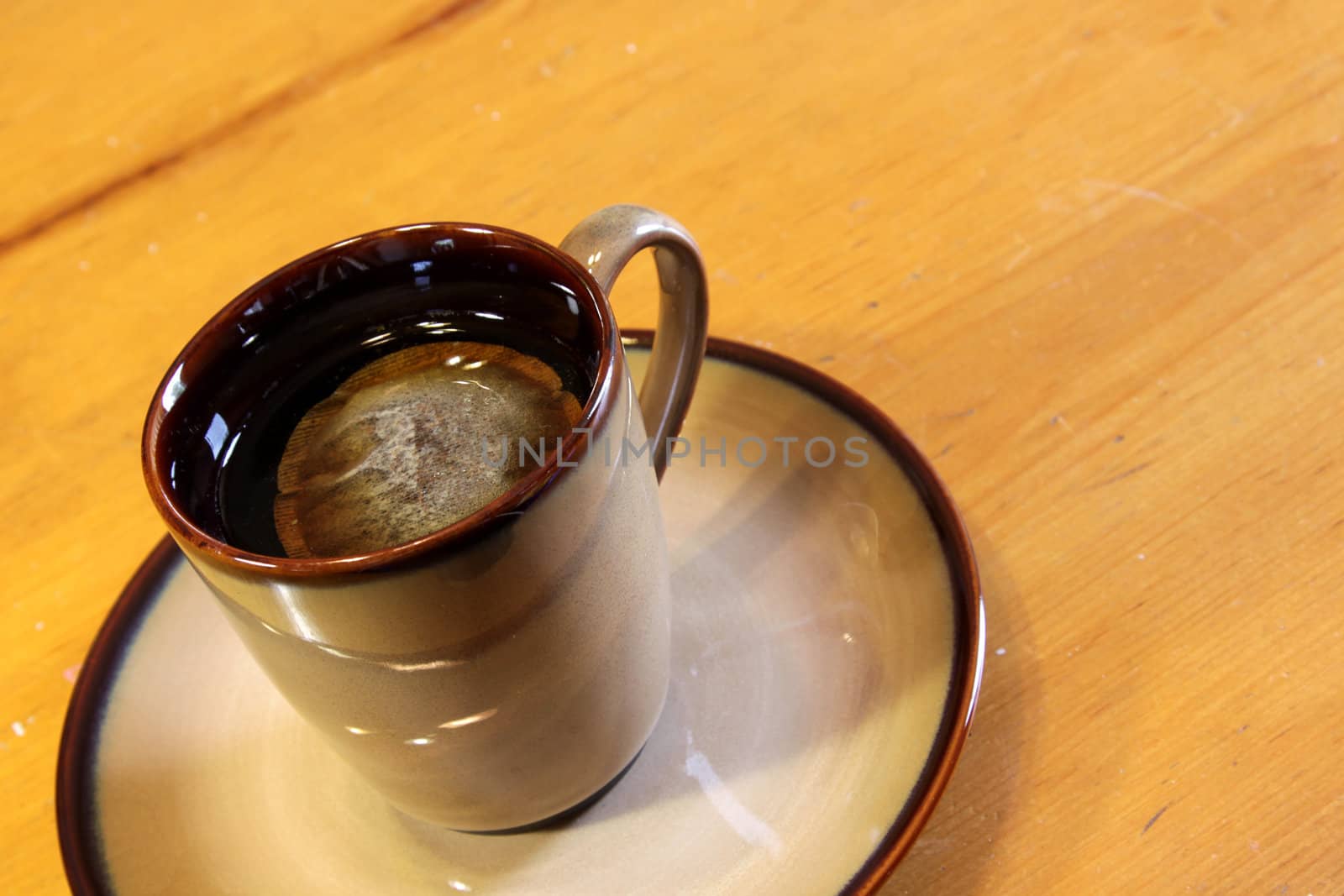 A bag of tea sitting a mug of hot water.
