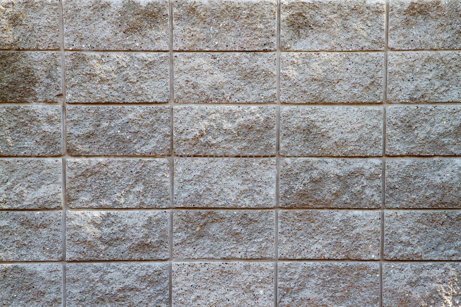 Several rows of a rough textured concrete block wall