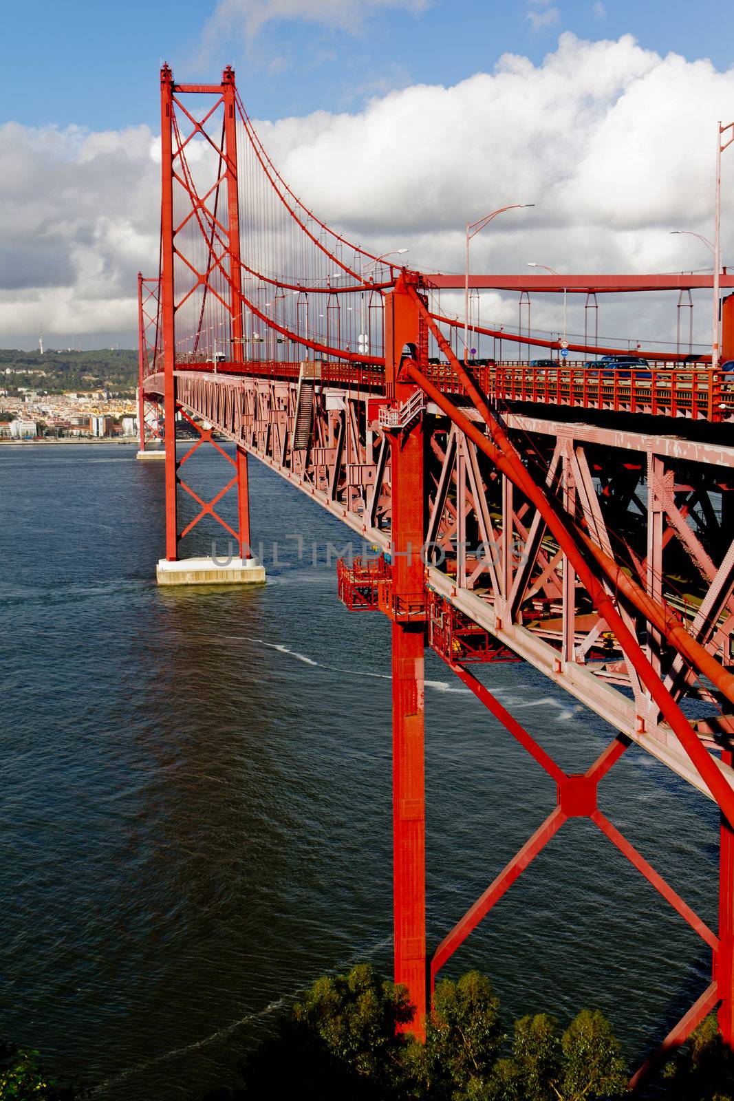 The 25 de Abril Bridge - suspension bridge over the river Tagus illuminated at night. Lisbon Portugal