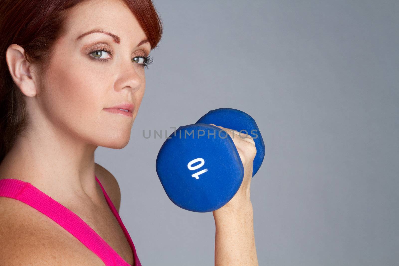 Pretty redhead woman lifting weights