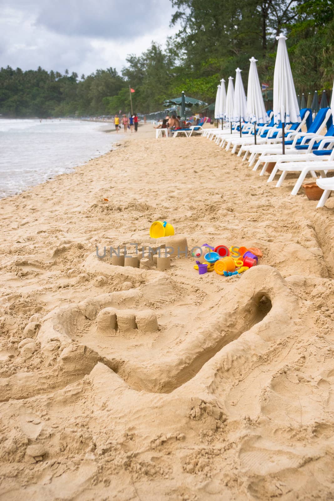 Children's multicolored toys on the sandy beach