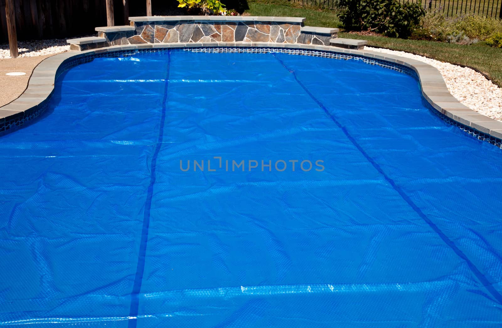 Bubble wrap like pool cover pulled over a swimming pool to keep in heat overnight