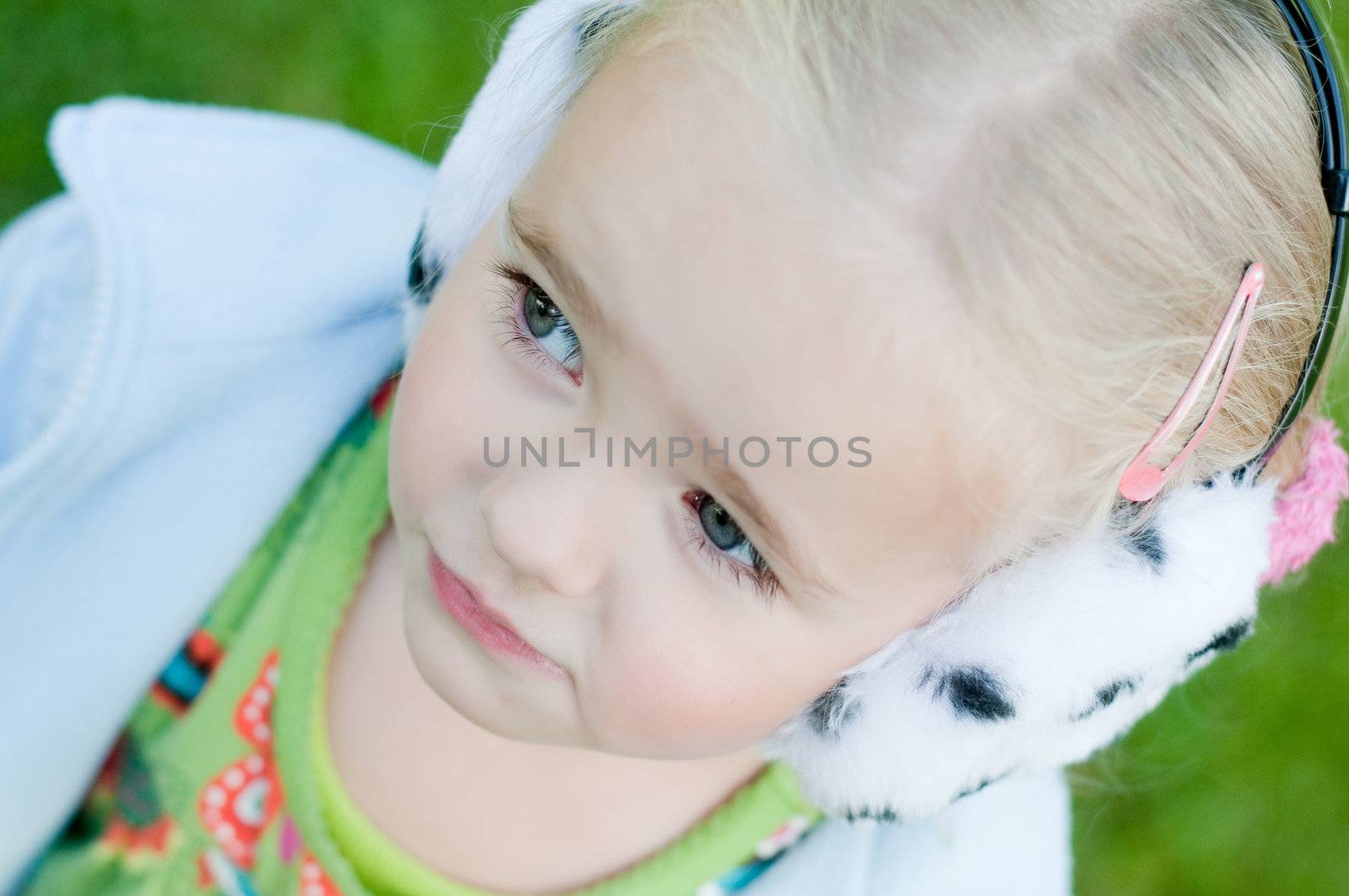 Shot of little girl in headphones playing outside