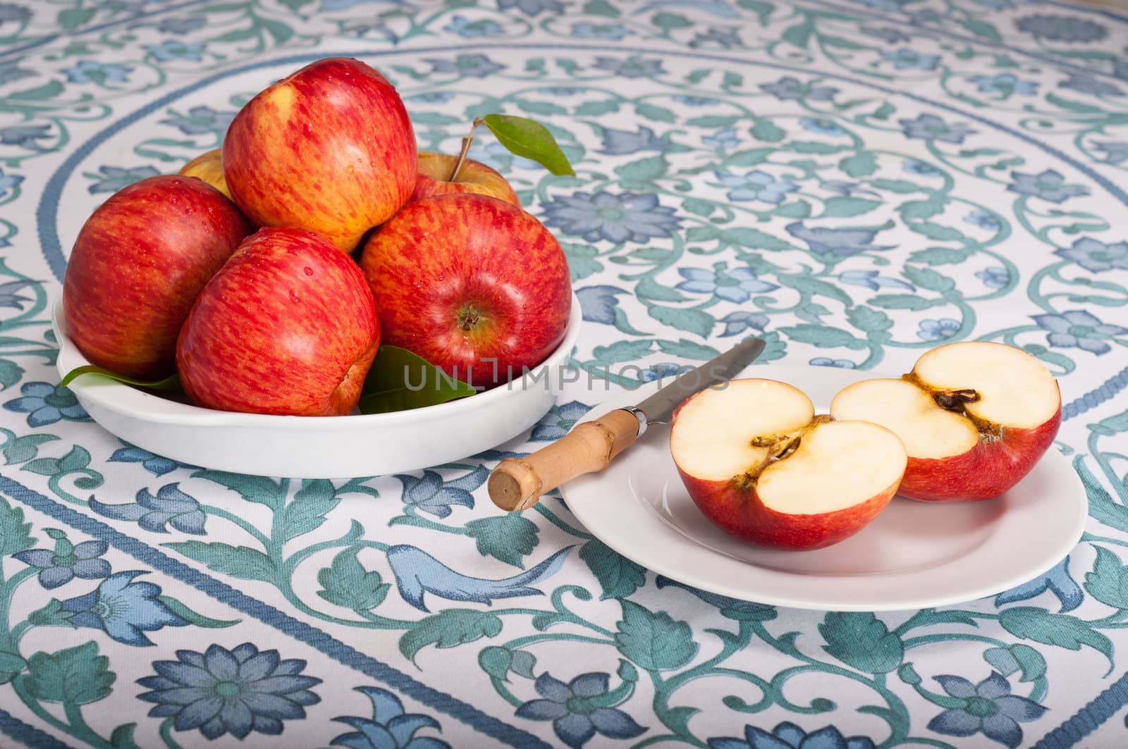 Fresh red apples on a table covered with blue and green cloth