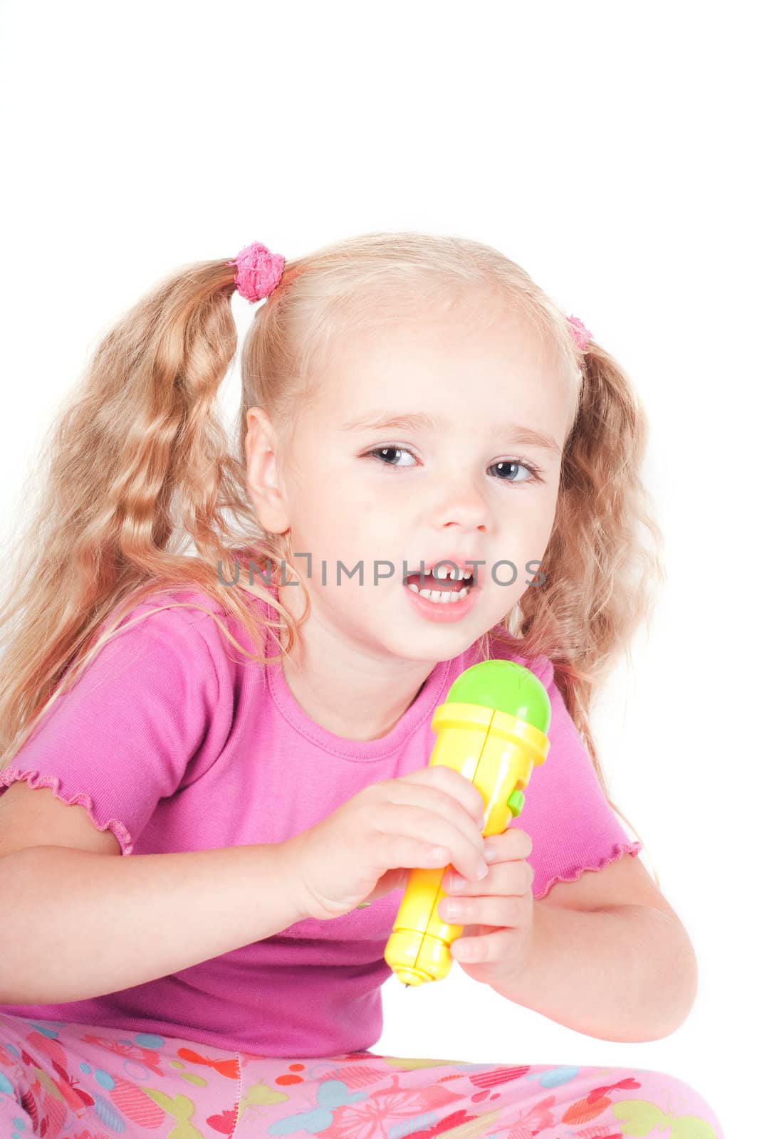 Little cute girl in pink and with ponytails in studio