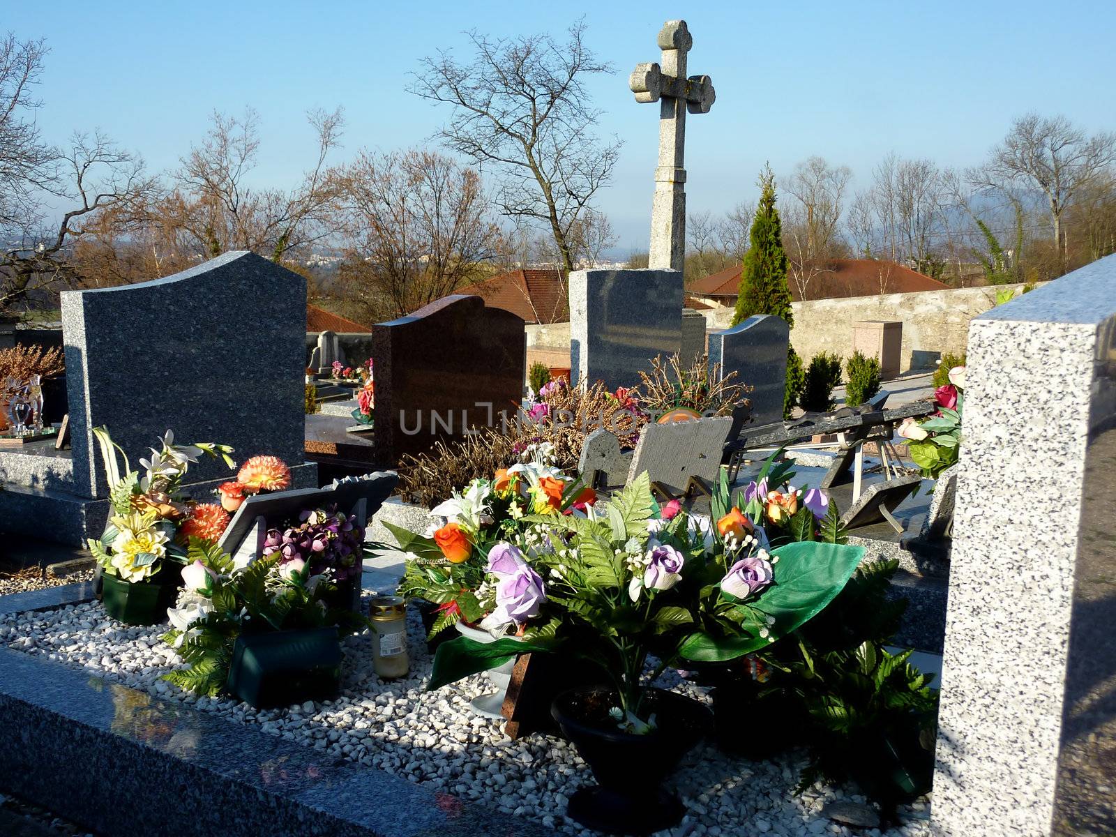 Lots of beautiful flowers covering a tomb in a cemetery