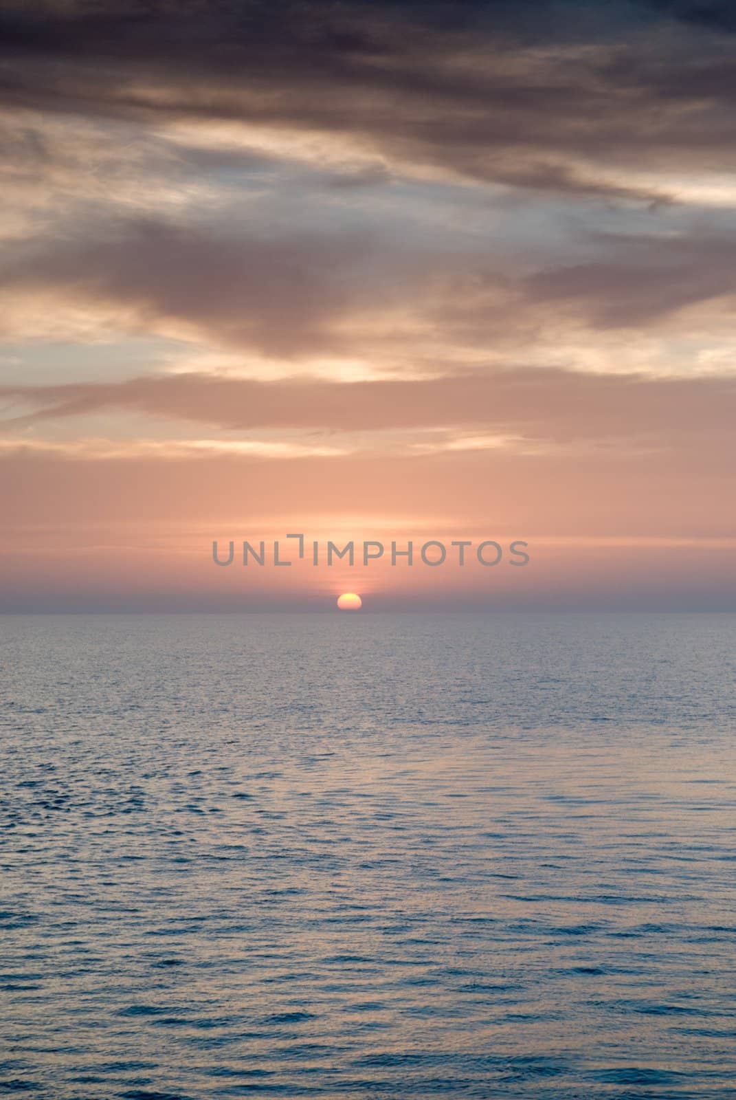 Sunrise and Dramatic sky over a clam ocean,