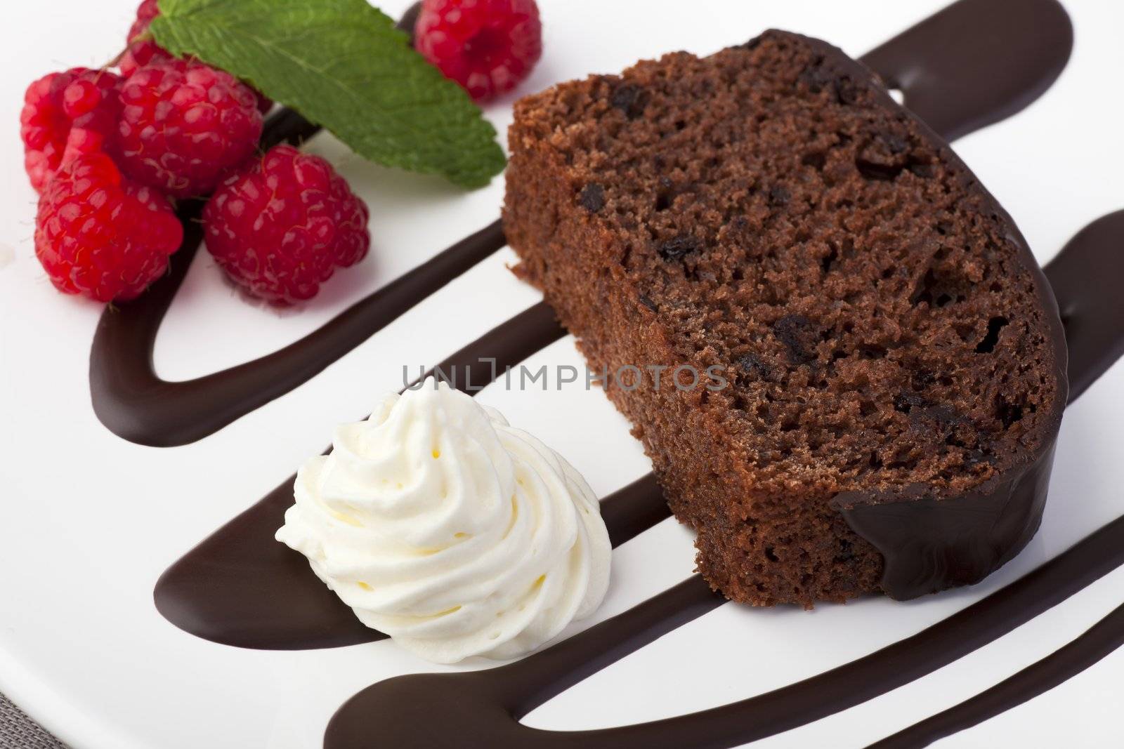 Fresh chocolate cake with raspberries and whipped cream.