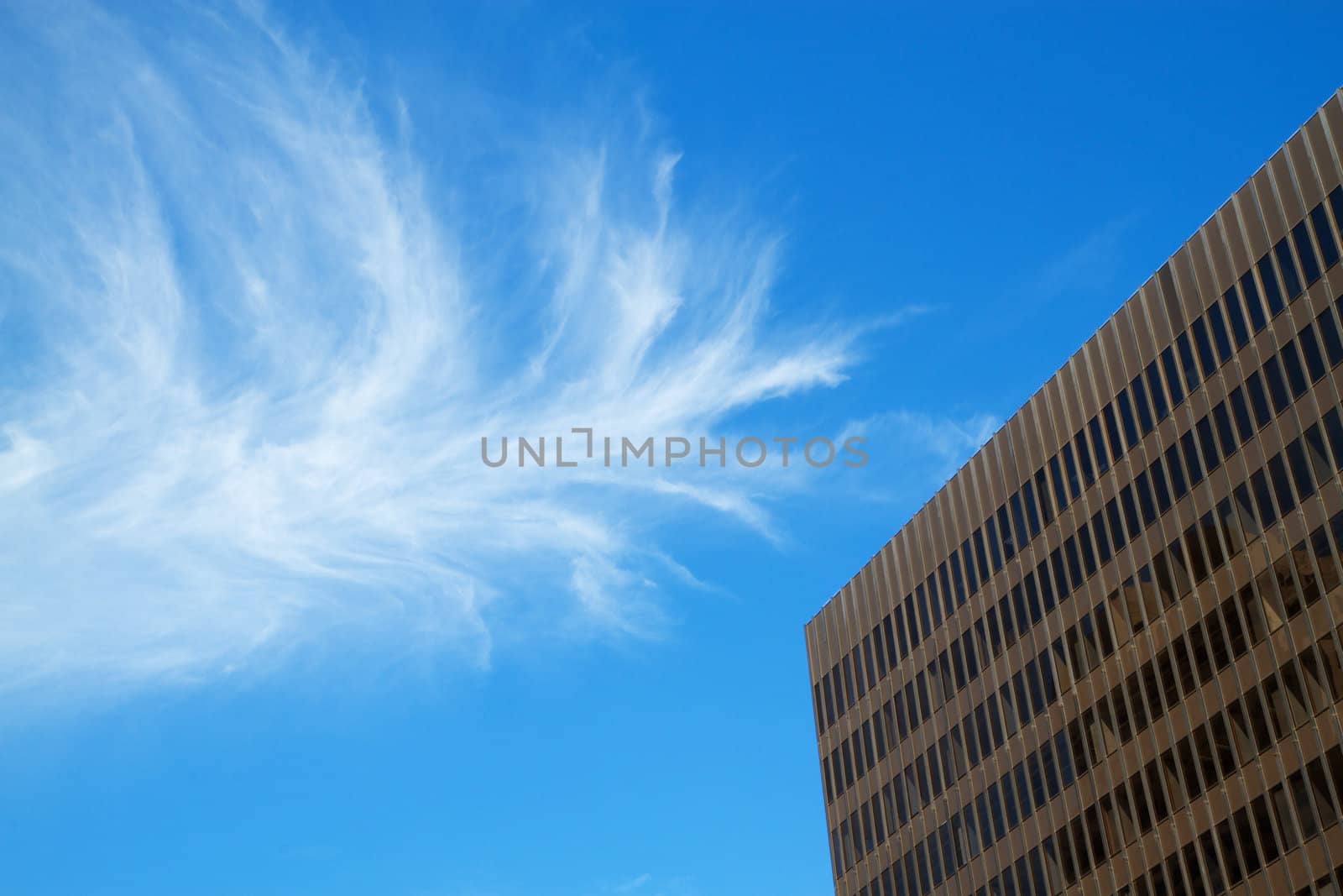 Brown office building with blue sky cloudscape