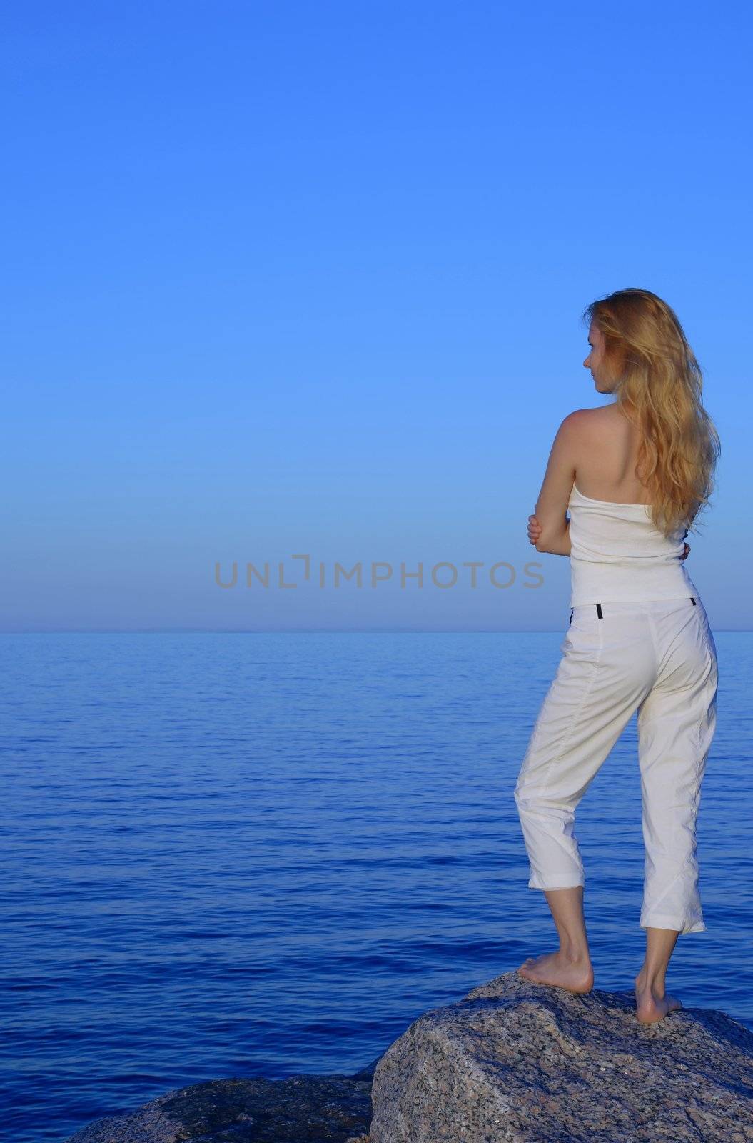 Calm young woman looking at the sea by anikasalsera