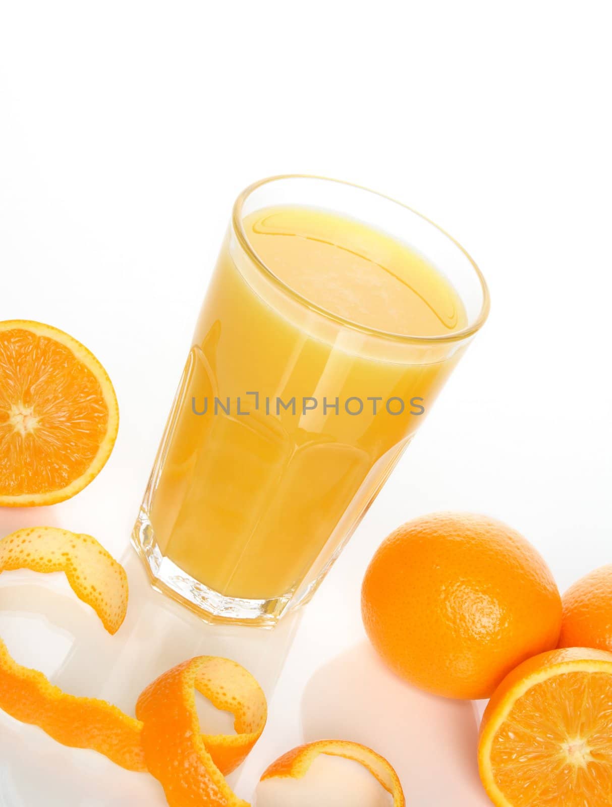 Glass of orange juice and tasty oranges.