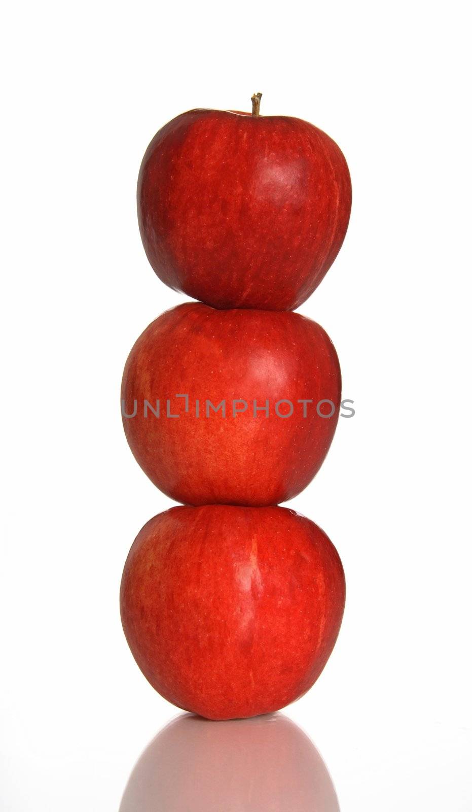 Balance. Three red apples one on another.
