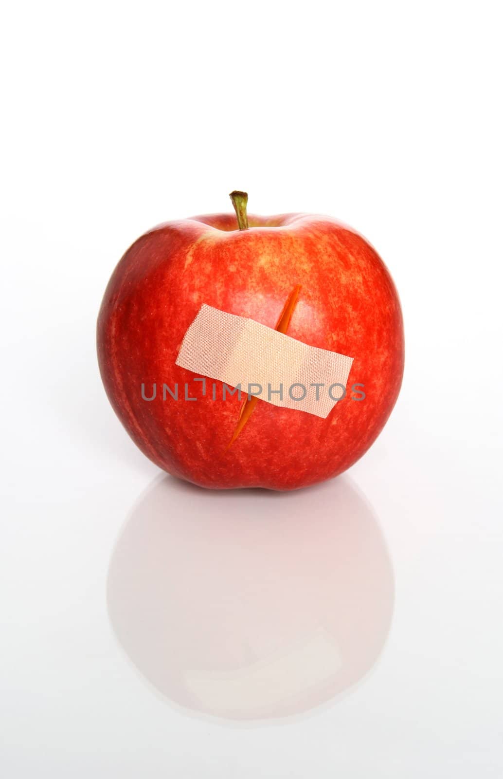 Injured red apple with a plaster.
