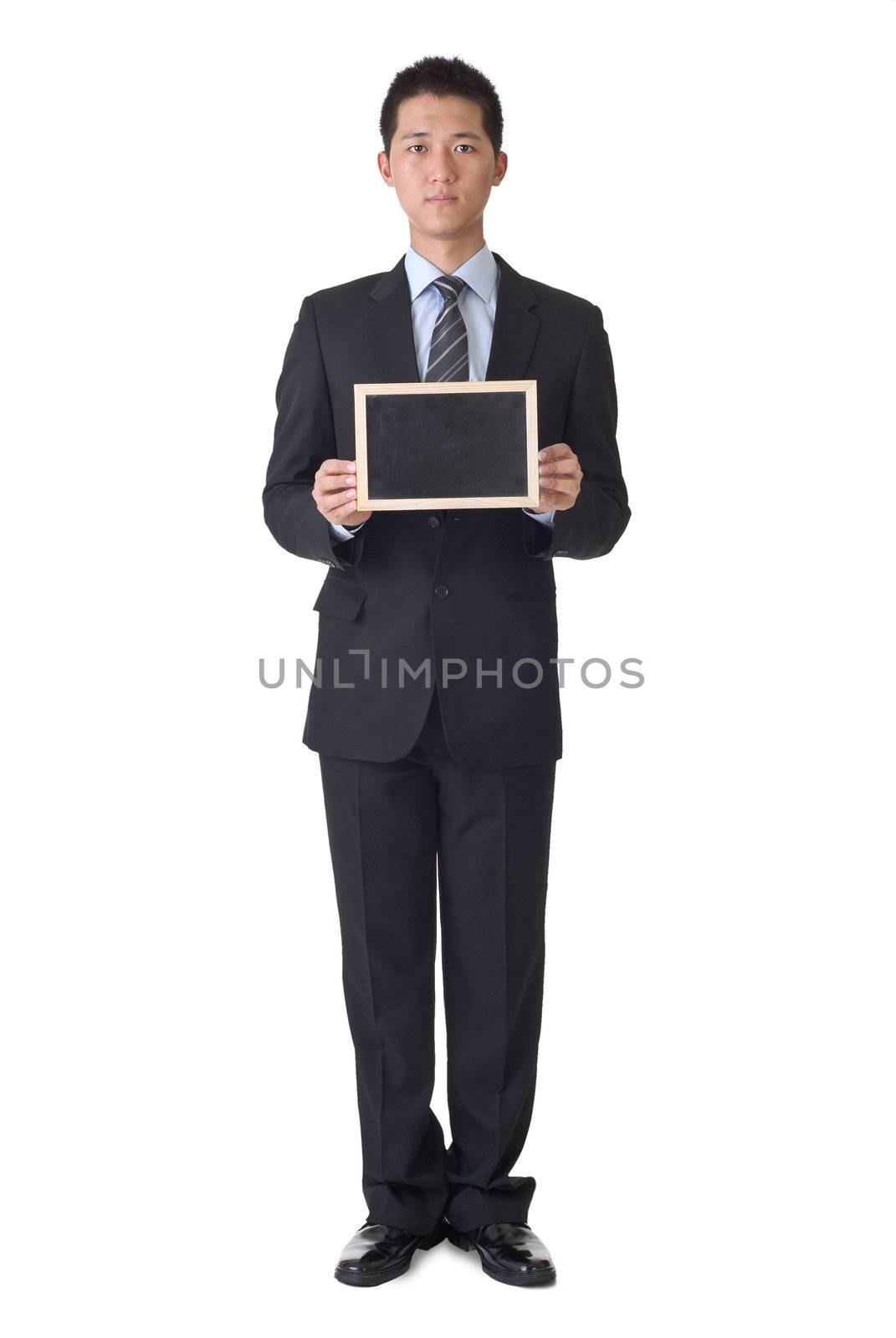 Business man holding blank blackboard, full length portrait on white background.