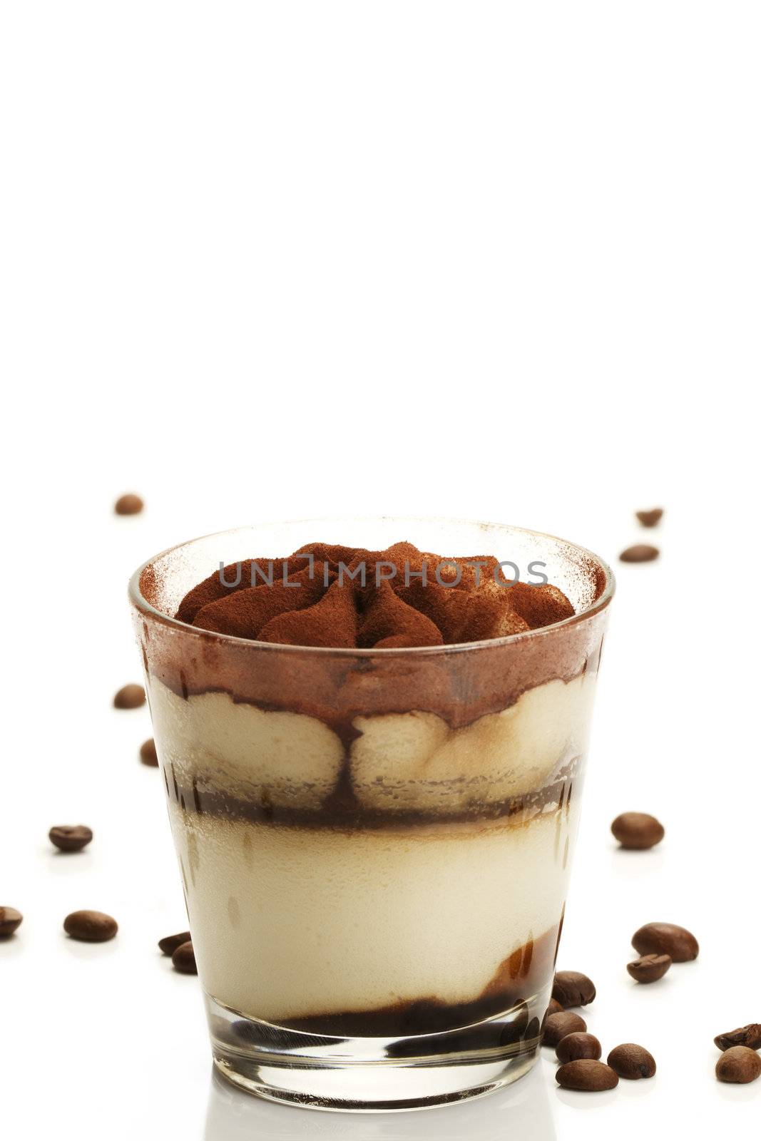 tiramisu in a glass with coffee beans on white background