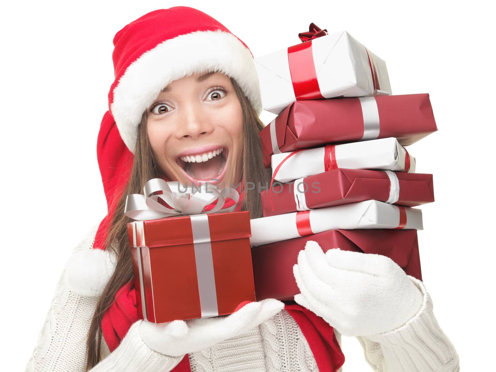 Christmas shopping woman holding gifts wearing red Santa hat. Funny santa woman portrait of a cute, beautiful smiling Asian / Caucasian model. Isolated on white background. 