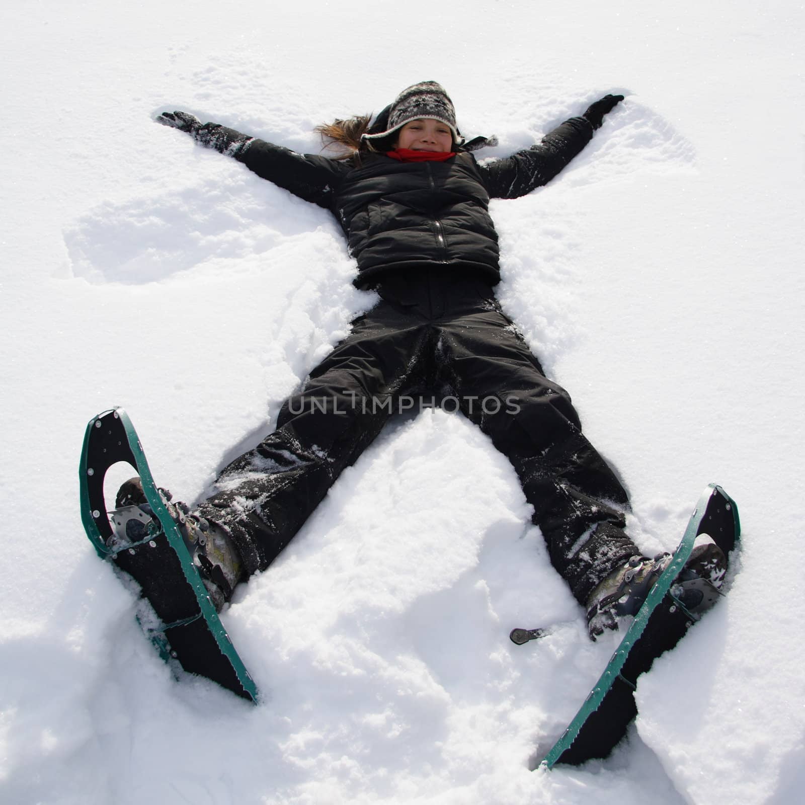 Girl having fun in the snow with snowshoes