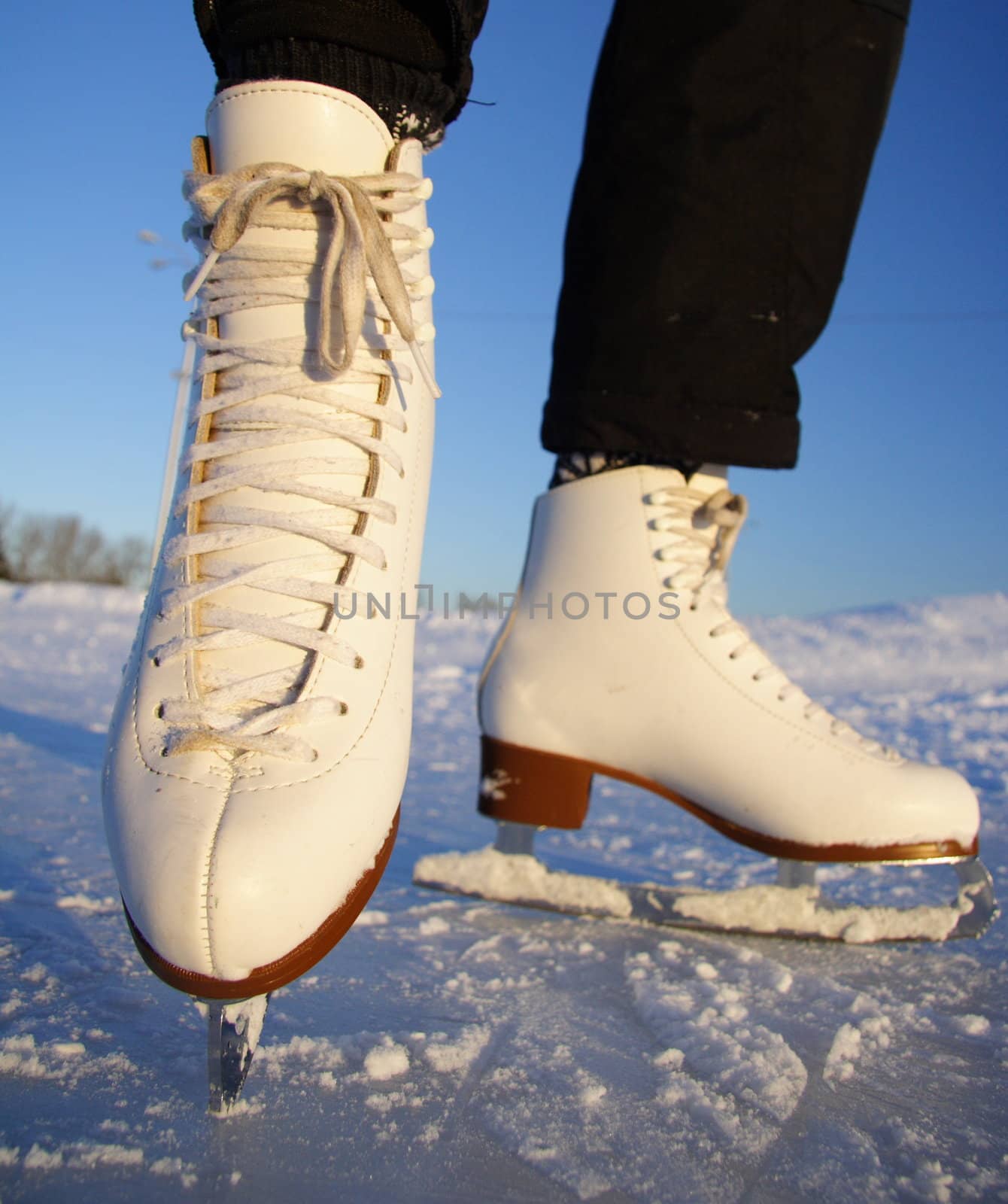 Closeup of figure skating ice skates in action outdoors
