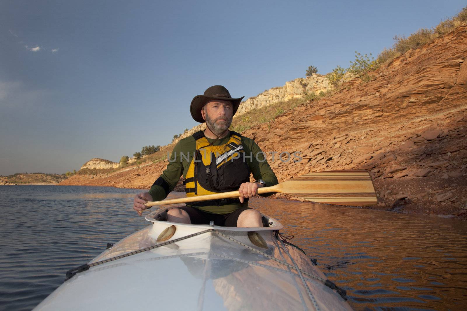 mature adult paddler in an expedition decked canoe on calm mountain lake (Horsetooth Reservoir near Fort Collins, Colorado)