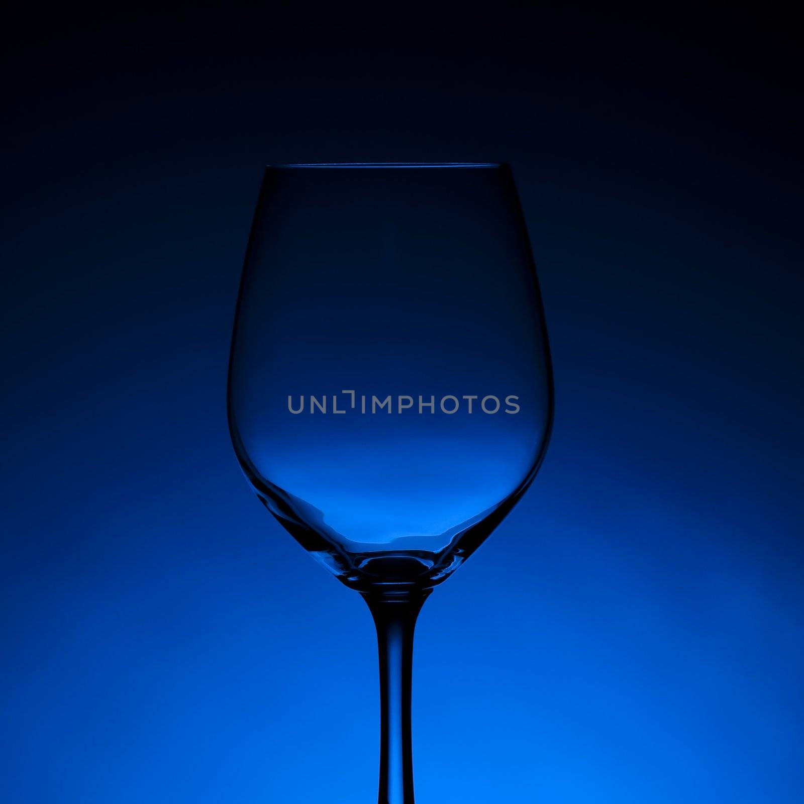 Empty wine glass with blue background.