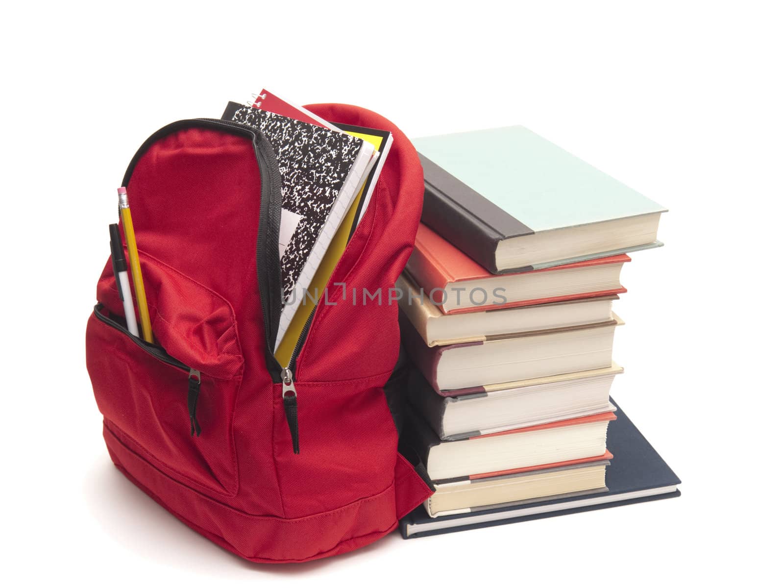 Back-to-school concept with red backpack stuffed with student materials. It is leaning against a stack of textbooks. Isolated on white for easy removal.