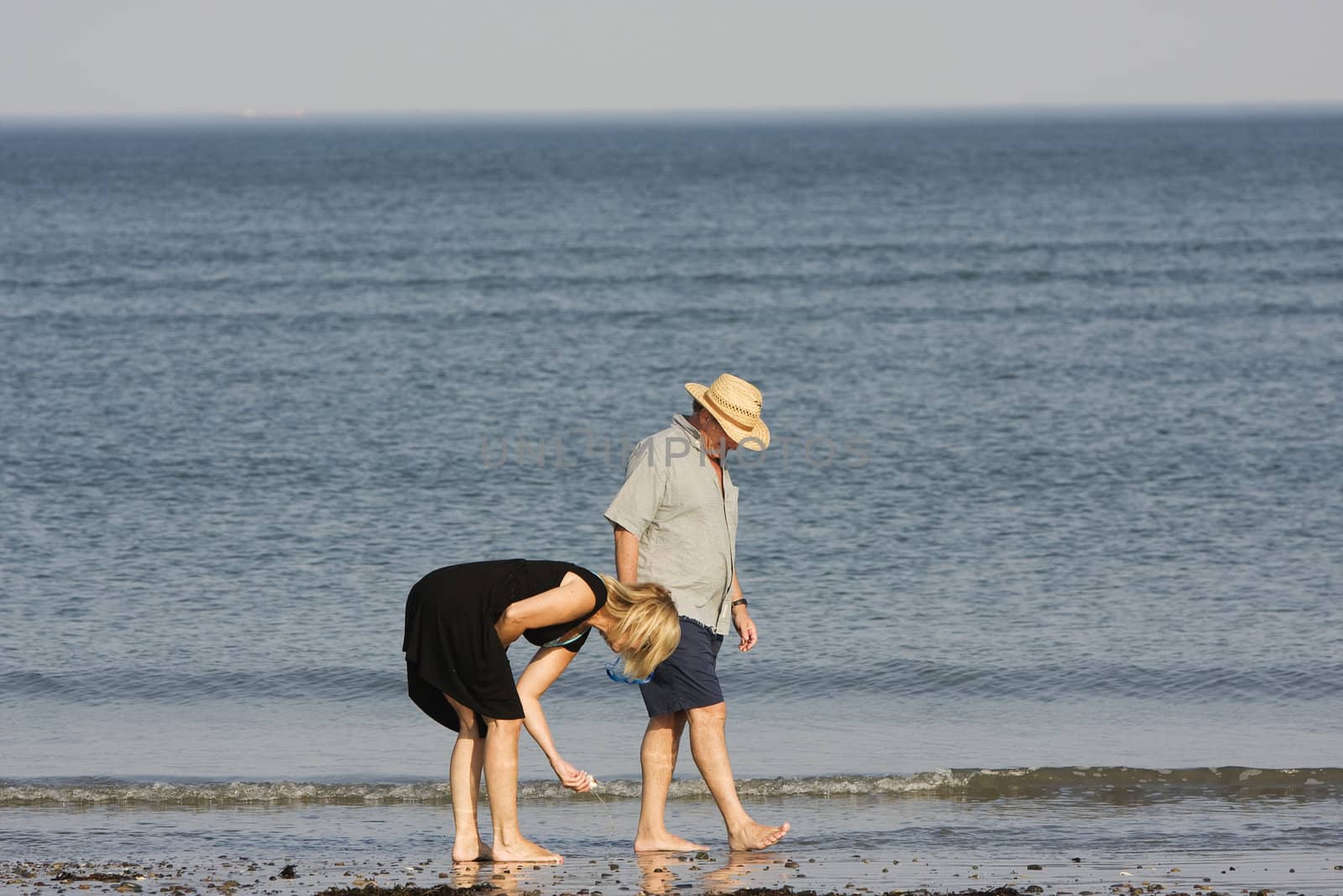 couple walking on a beach by joey19840717