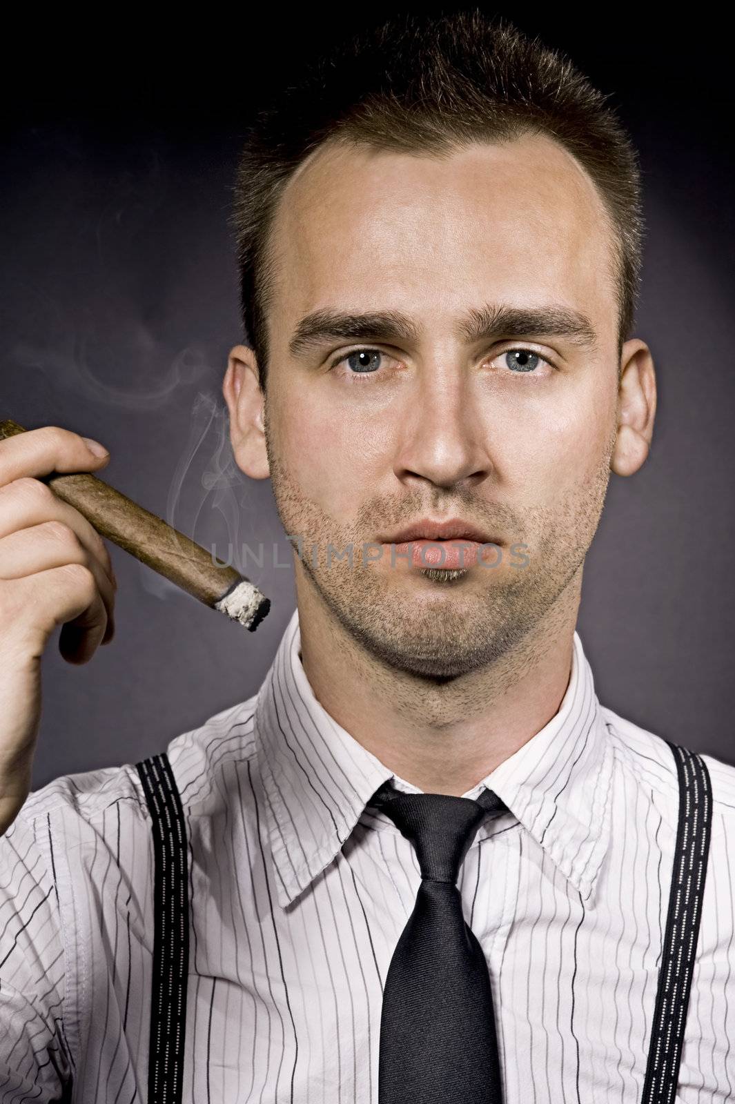 young handsome confident man smoking cigaro