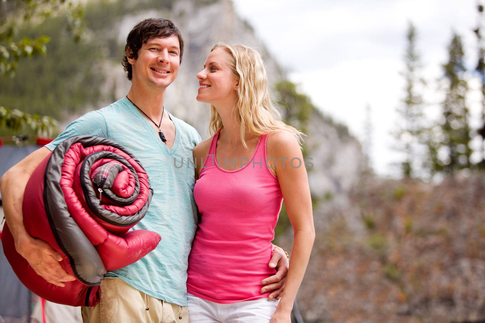 A happy couple camping in the wilderness