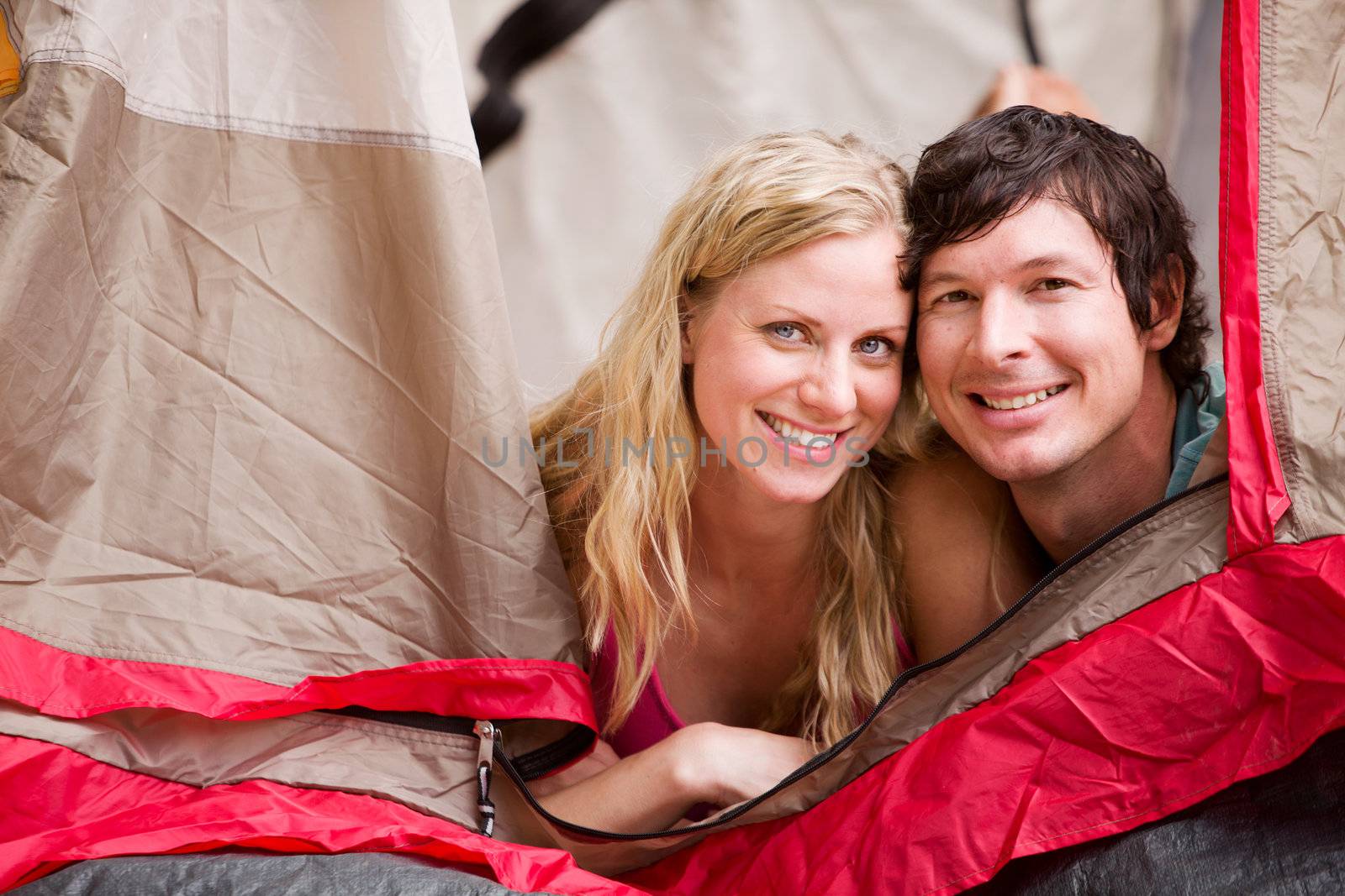 A portrait of a couple smiling in a tent