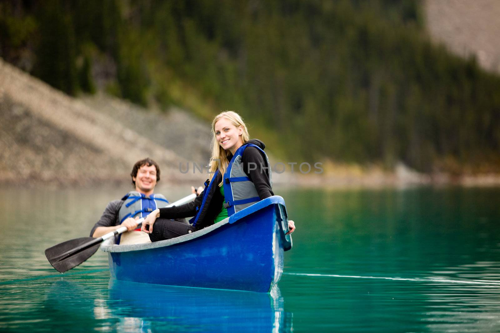 A portrait of a happy woman on a canoeing trip with a man