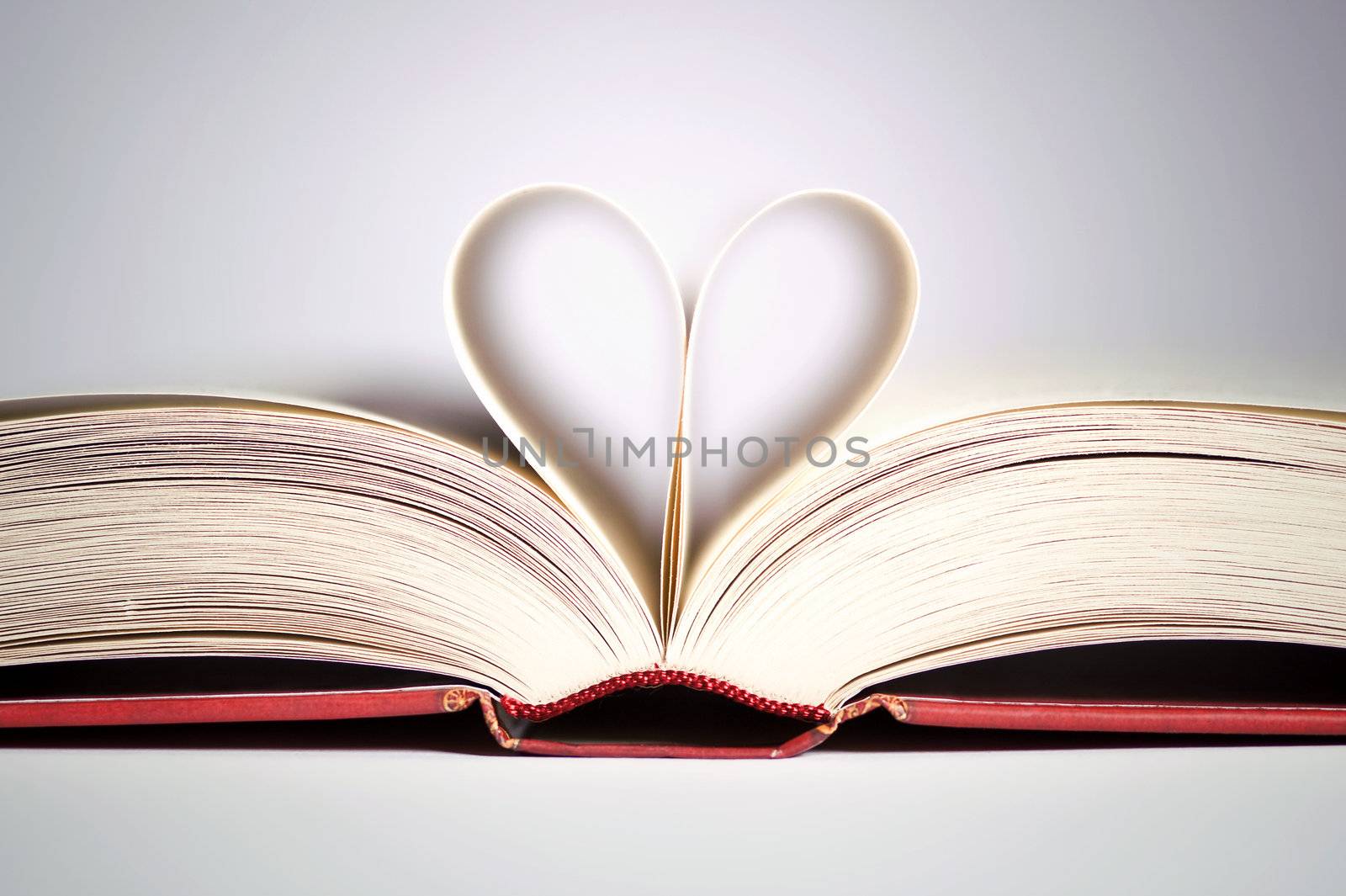 book with heart shaped pages over gradient background
