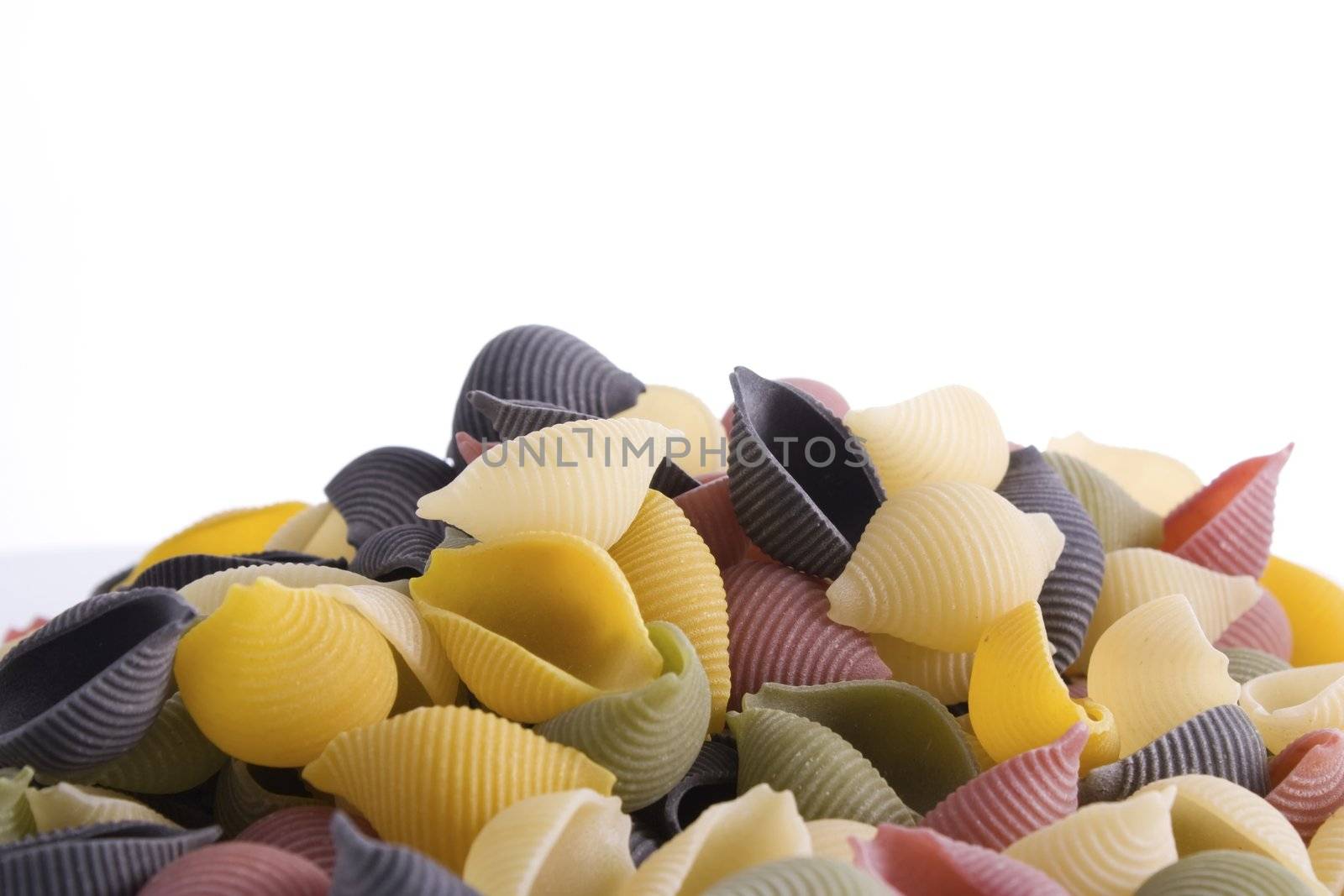 Mound of uncooked pasta shells with white background