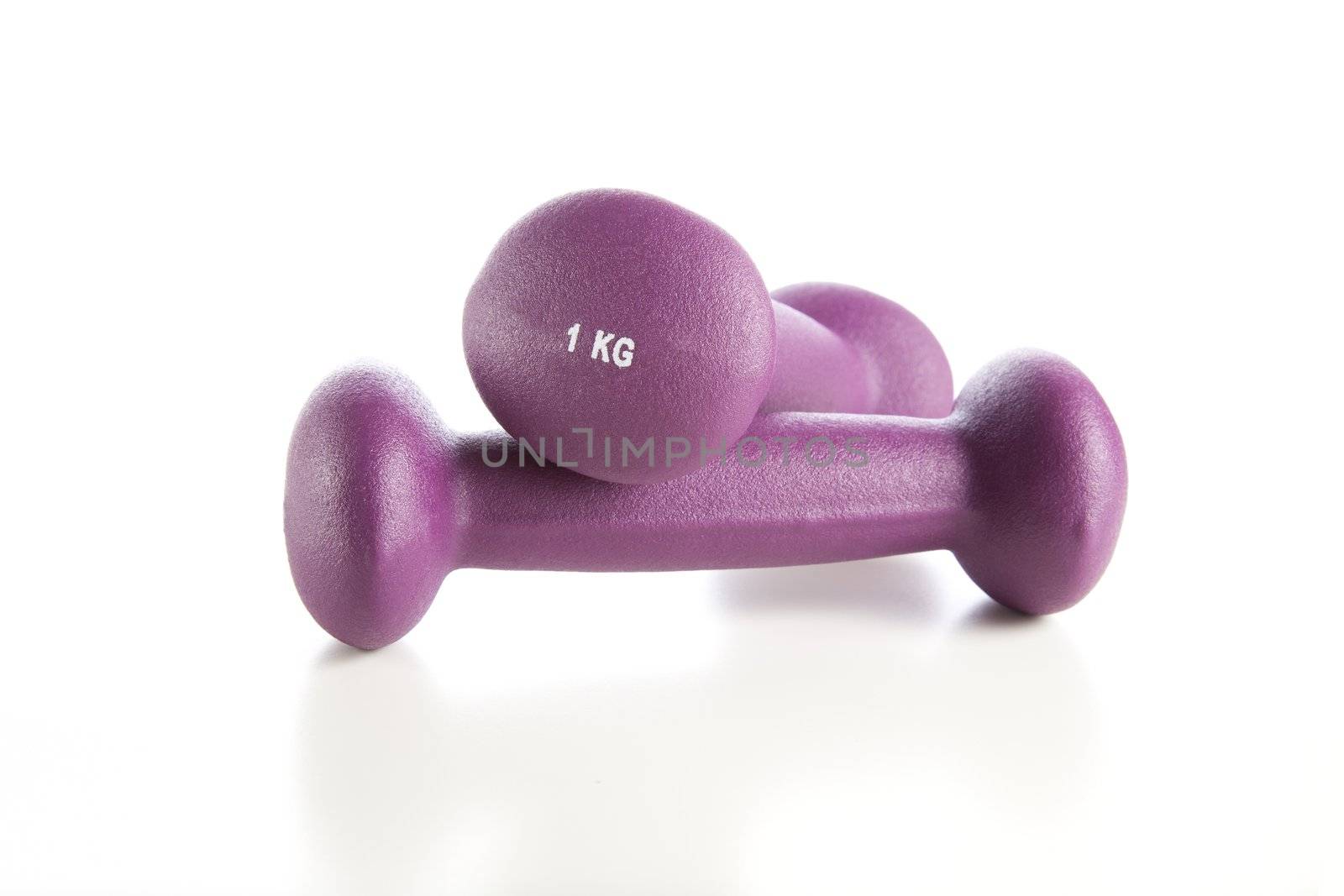 Two dumbbell weights isolated on white with reflections in table.