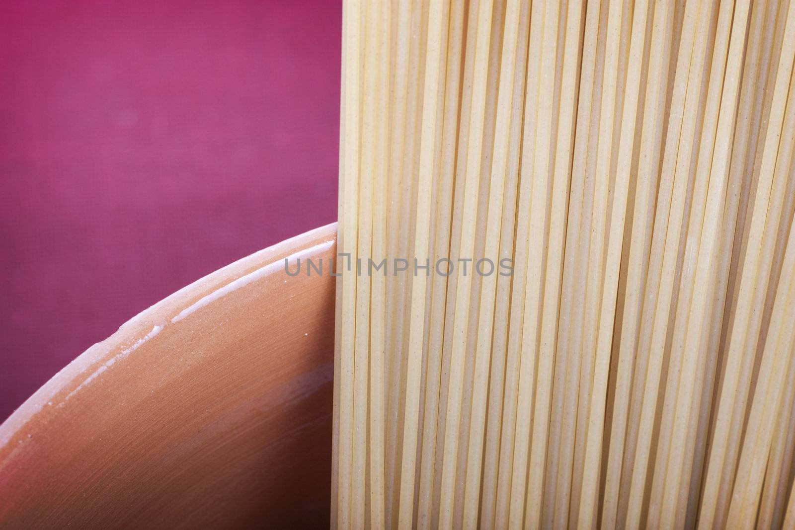 Closeup of spaghetti in earthenware container.