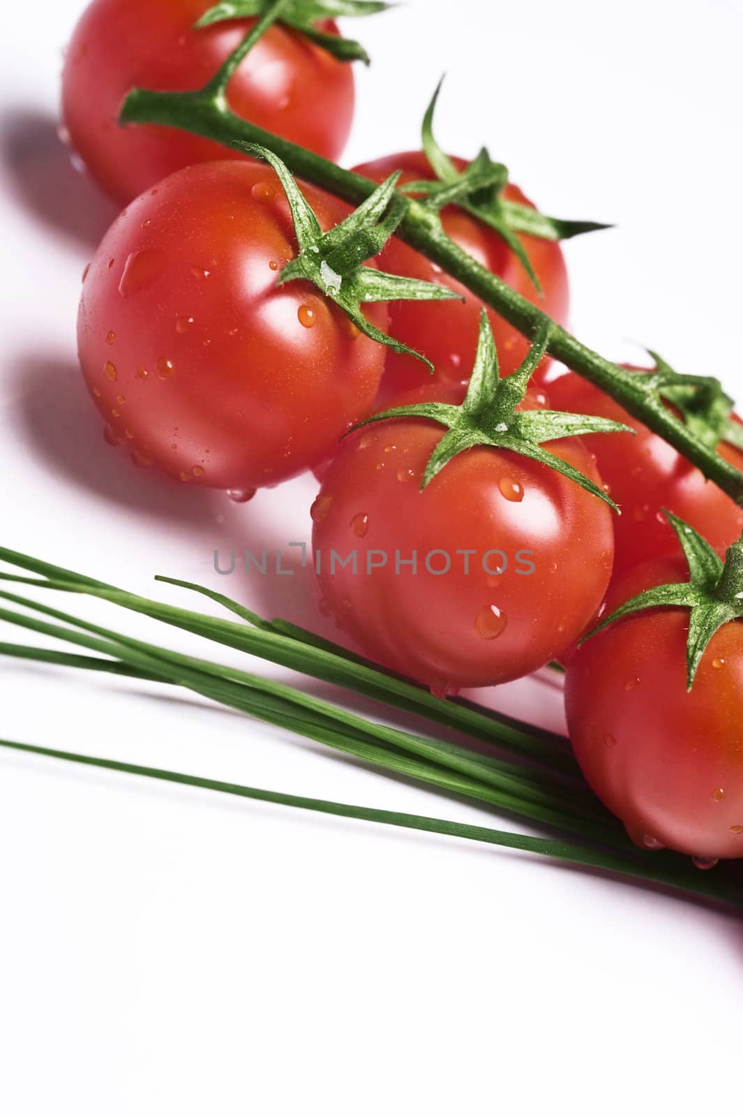 fresh wet tomatoes and chive on table