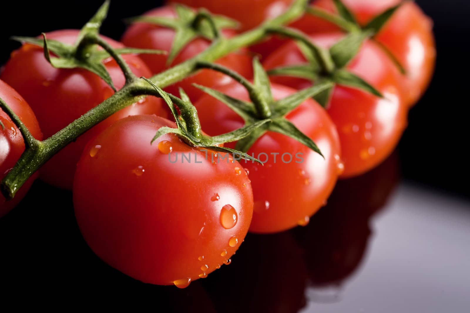 fresh and wet tomatoes on the black table