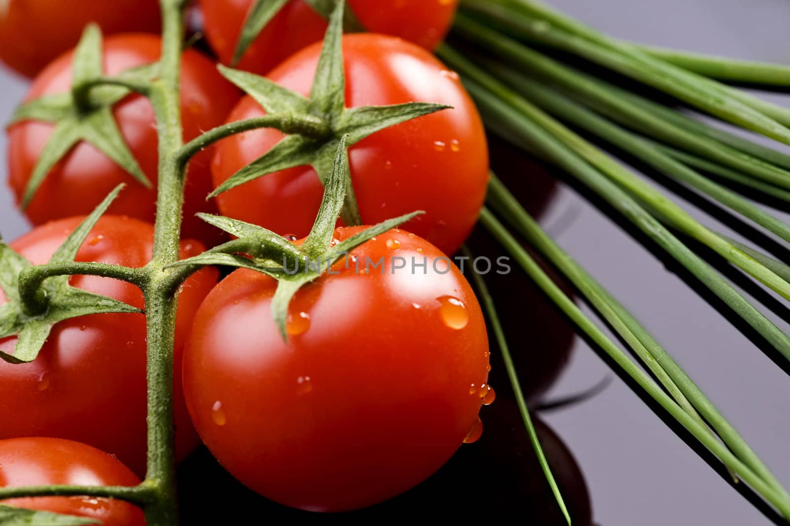 fresh wet tomatoes and chive on table
