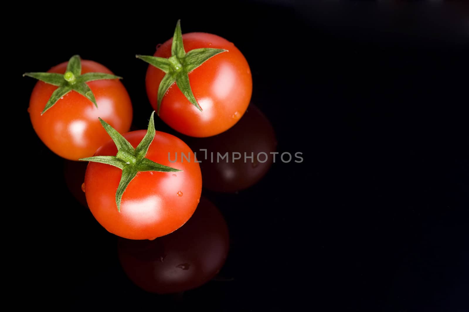 fresh three tomatoes on the black table
