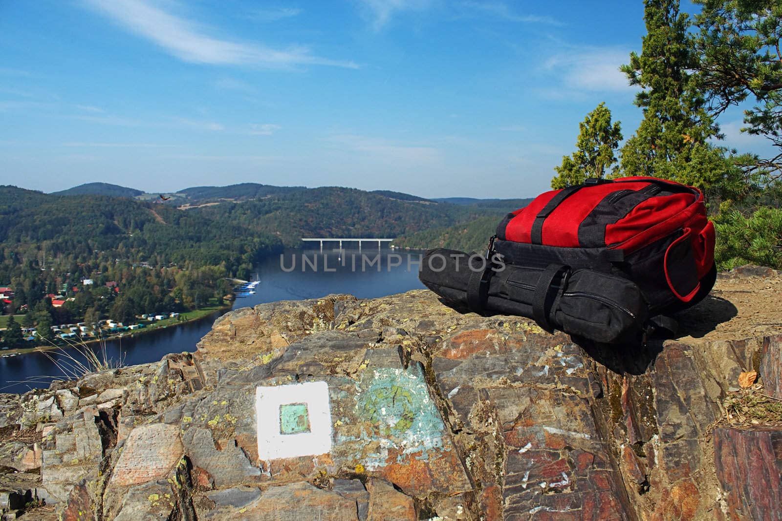 Backpacks lying on a rock at the prospect of water